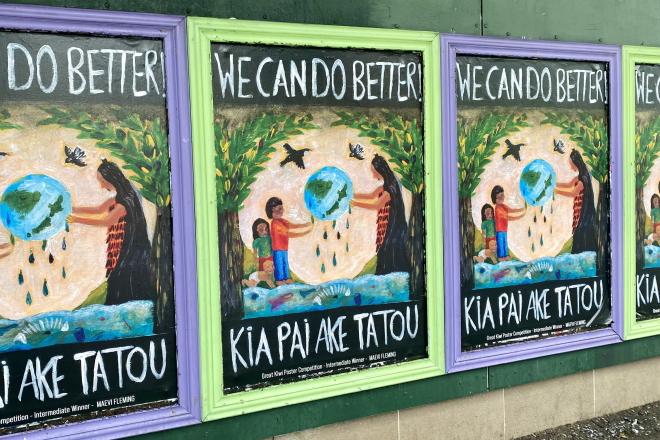 Photograph of a line of identical, colorful posters with the text "We Can Do Better! Kia Pai Ake Tatou"